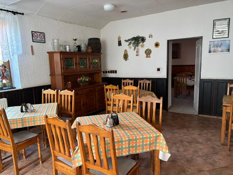 Jídelna s kostkovanými ubrusy a krbovými kamny